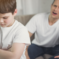 Angry father disciplining child's bad behavior with possible spanking.